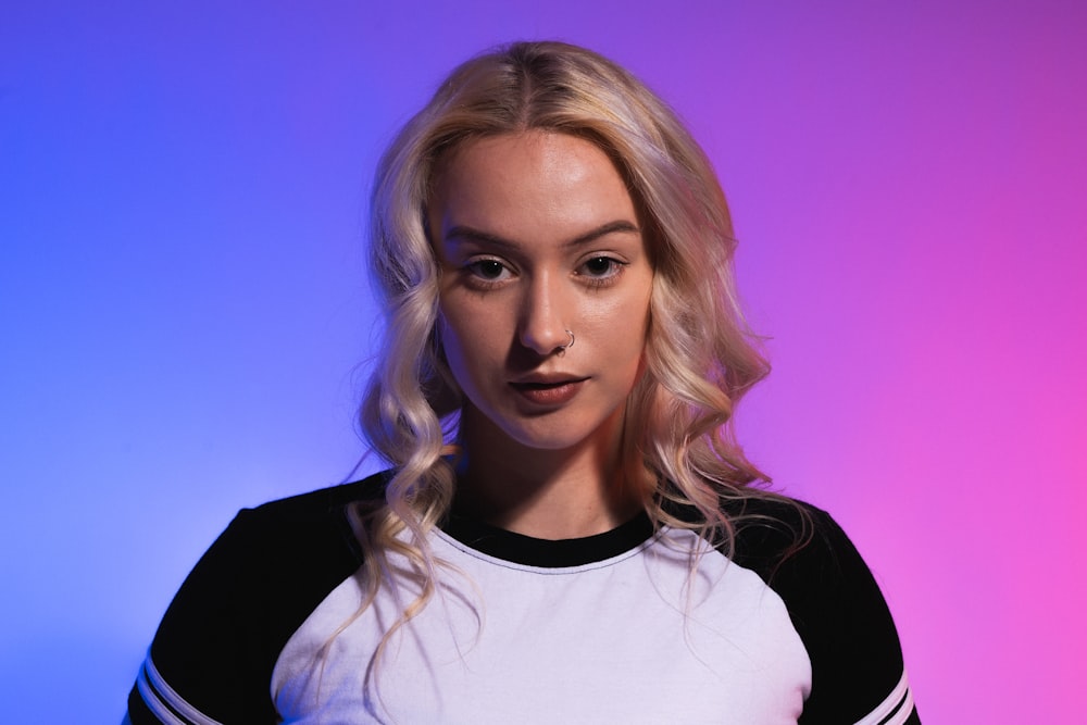 a woman with blonde hair wearing a black and white shirt