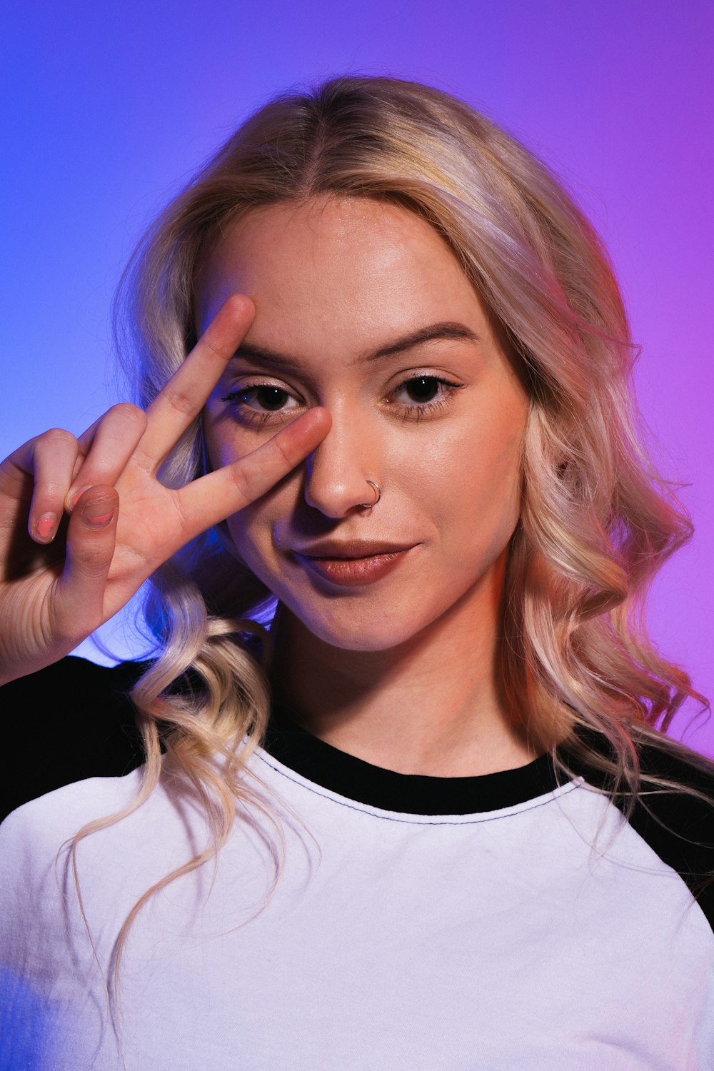 a woman making a peace sign with her fingers