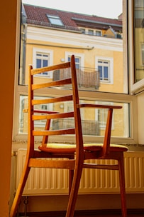 A beautifully crafted wooden chair placed in a sunlit room.