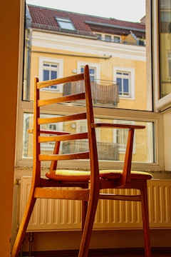 A professional assembling a wooden chair in a bright living room.