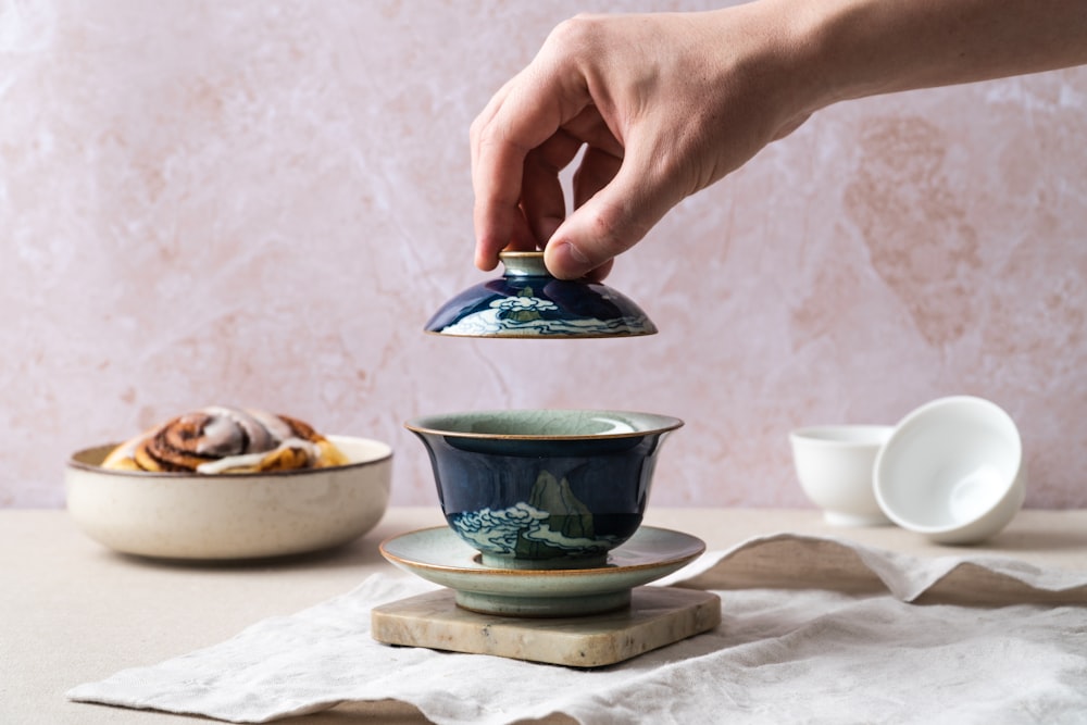 a person is pouring tea into a teacup