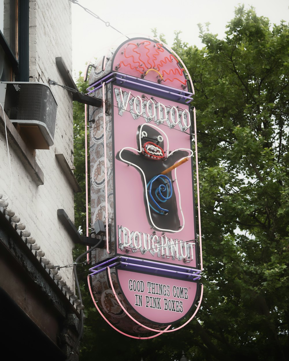 a neon sign hanging from the side of a building