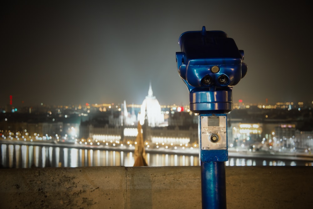 a blue parking meter sitting on the side of a road