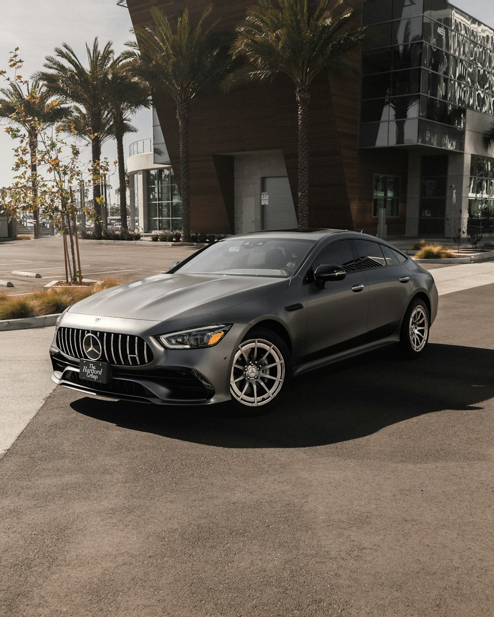 a grey mercedes benz coupe parked in front of a building