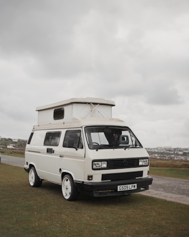 Close-up of hands working on vehicle documents with a camper van in the background.