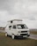 A happy customer holding a Fiat Ducato replacement part in front of their camper van.