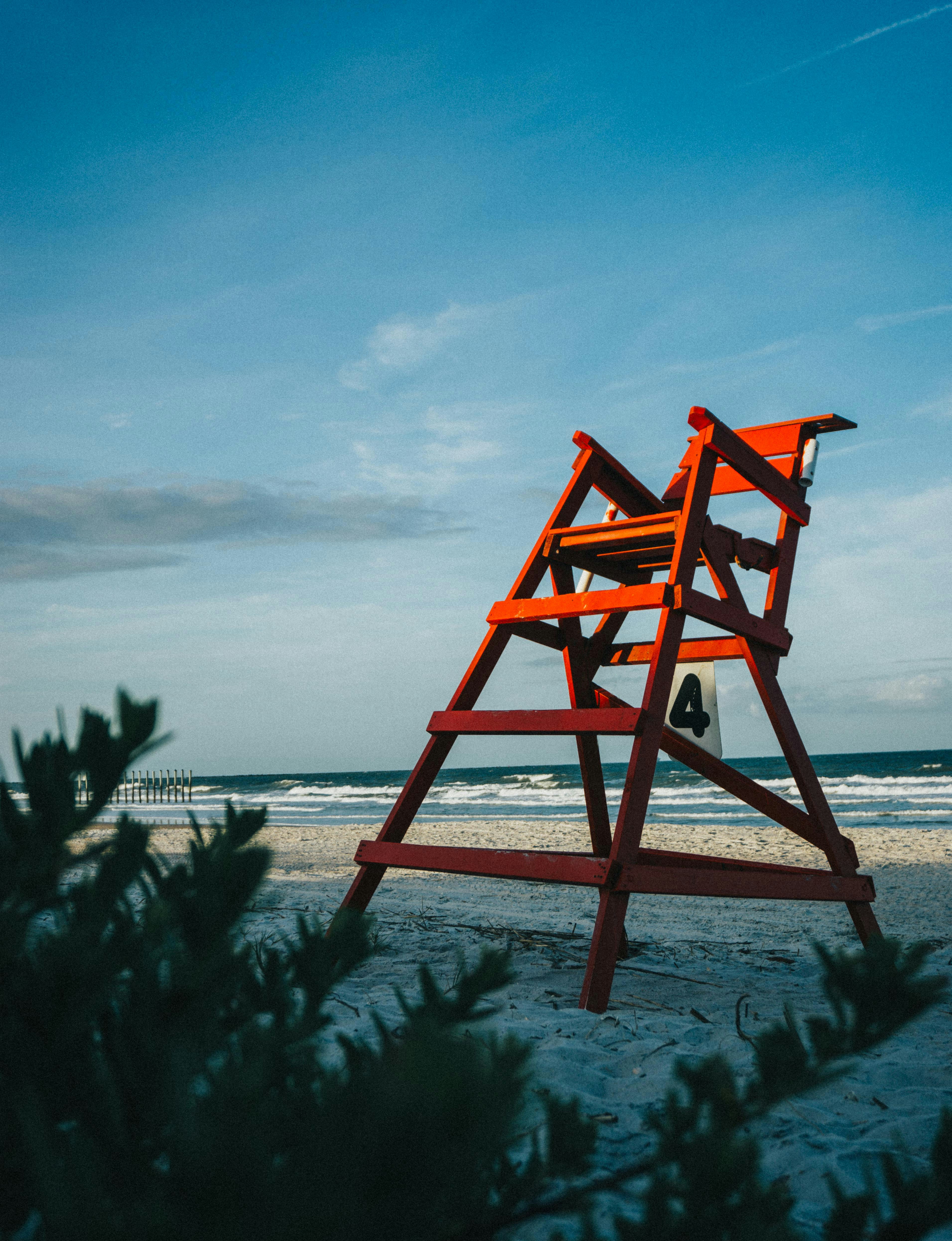 a lifeguard stand on the beach with a blue sky in the background