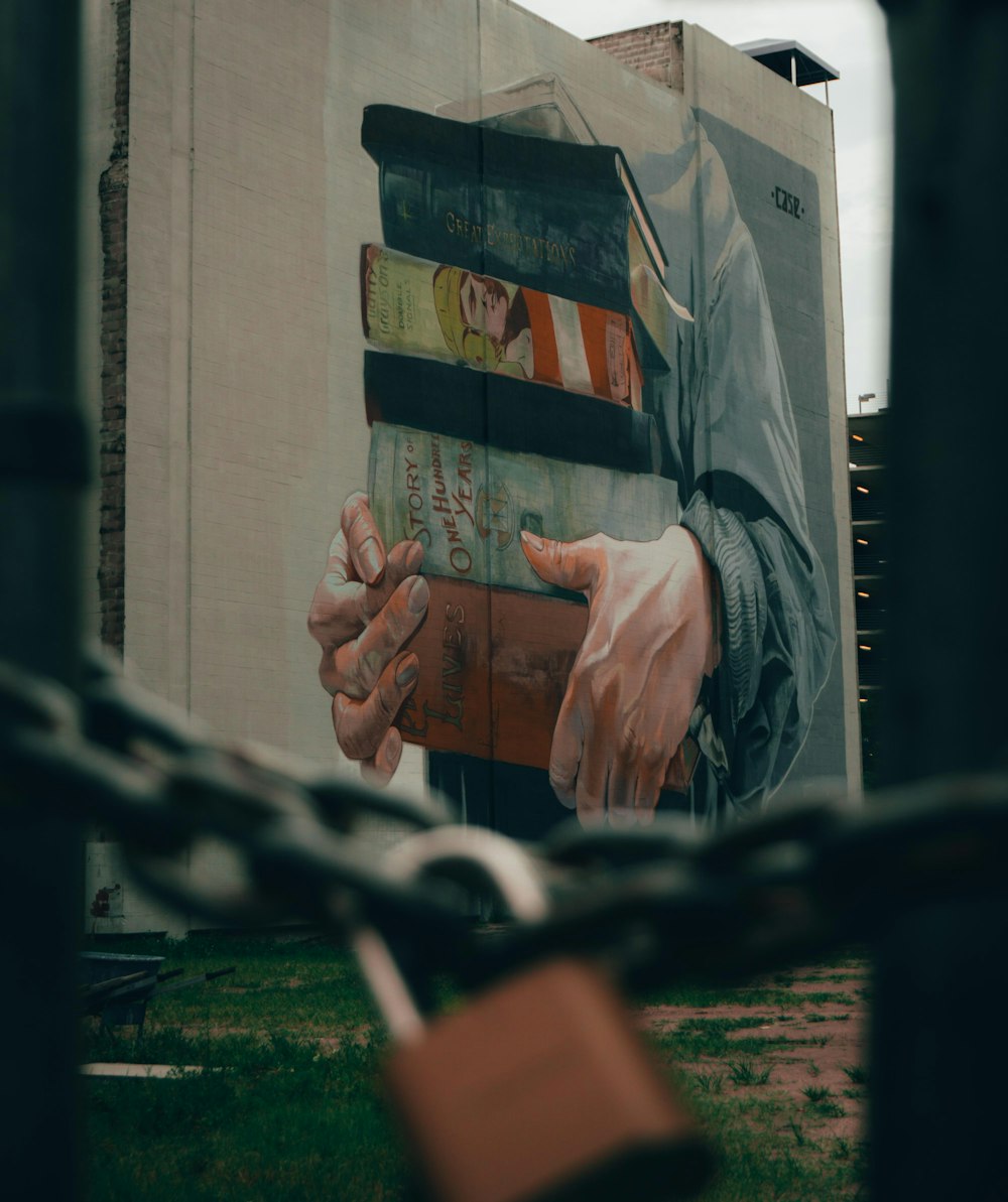 a large mural of a man holding a stack of books