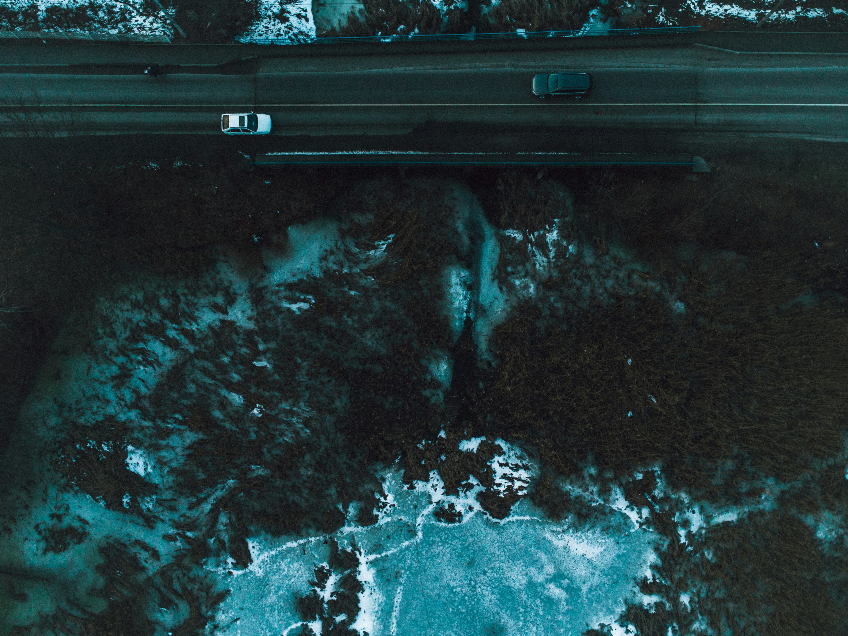 an aerial view of a road with snow on the ground