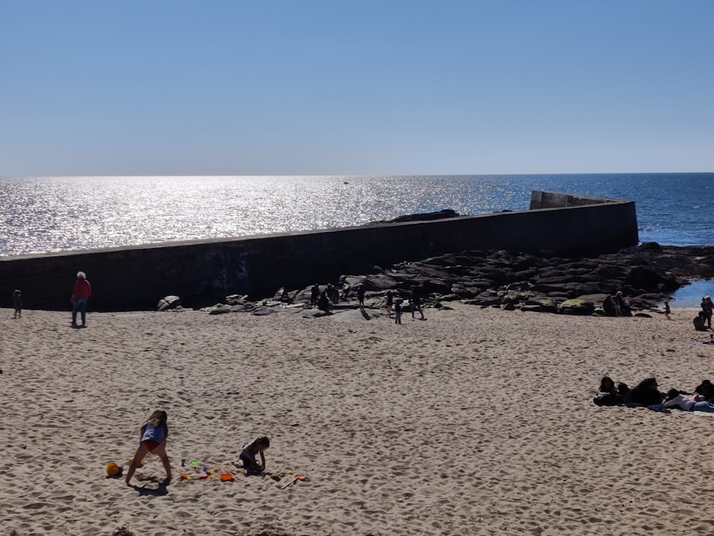 a group of people sitting on top of a sandy beach