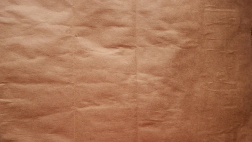 A close-up of textured paper with faint, irregular ink marks.