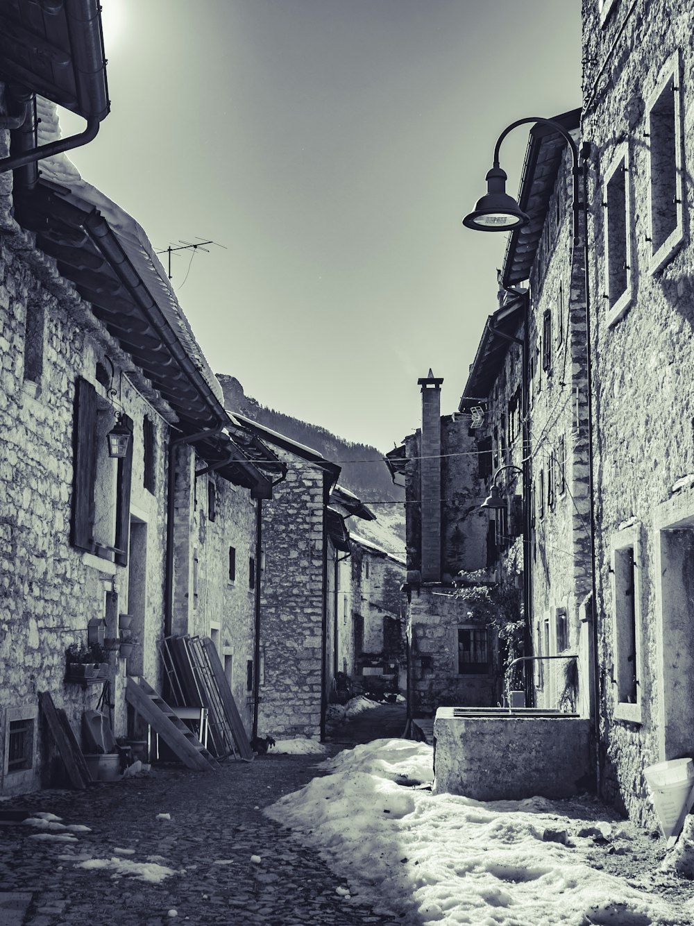 a narrow street with snow on the ground