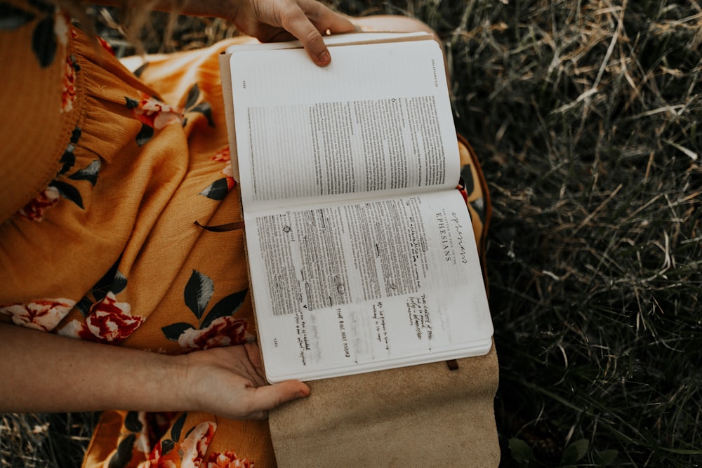 uma pessoa segurando um livro em suas mãos