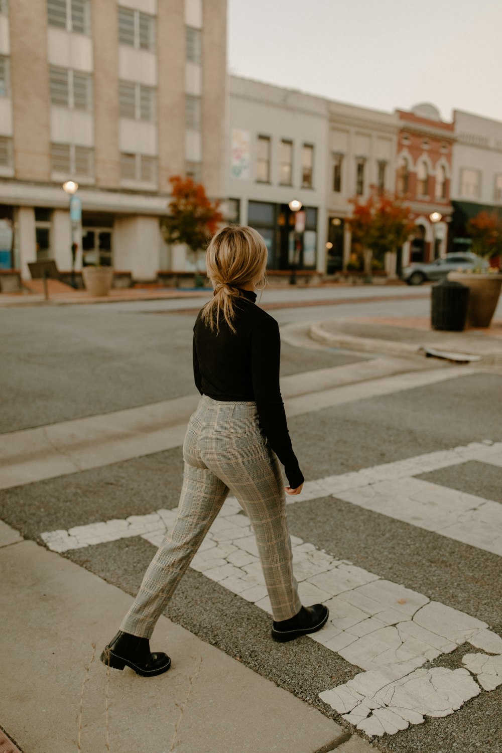 uma mulher atravessando a rua em uma faixa de pedestres