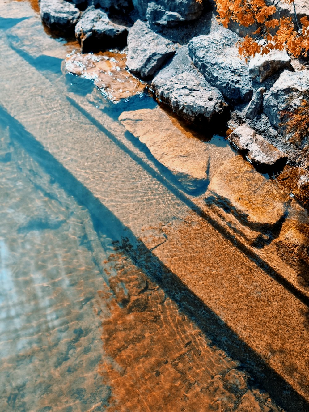 a rock wall next to a body of water