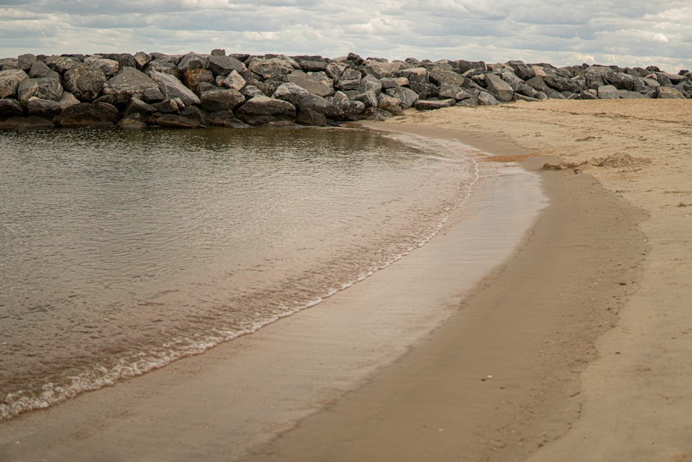 a sandy beach next to a body of water