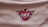 A logo set against a textured white fabric background, featuring a stylized phoenix above a basketball. The letters 'PHX' are prominently displayed in a bold font at the center.