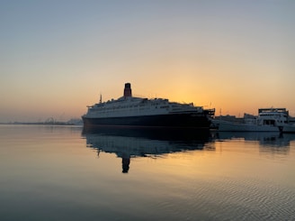 a cruise ship in the water at sunset