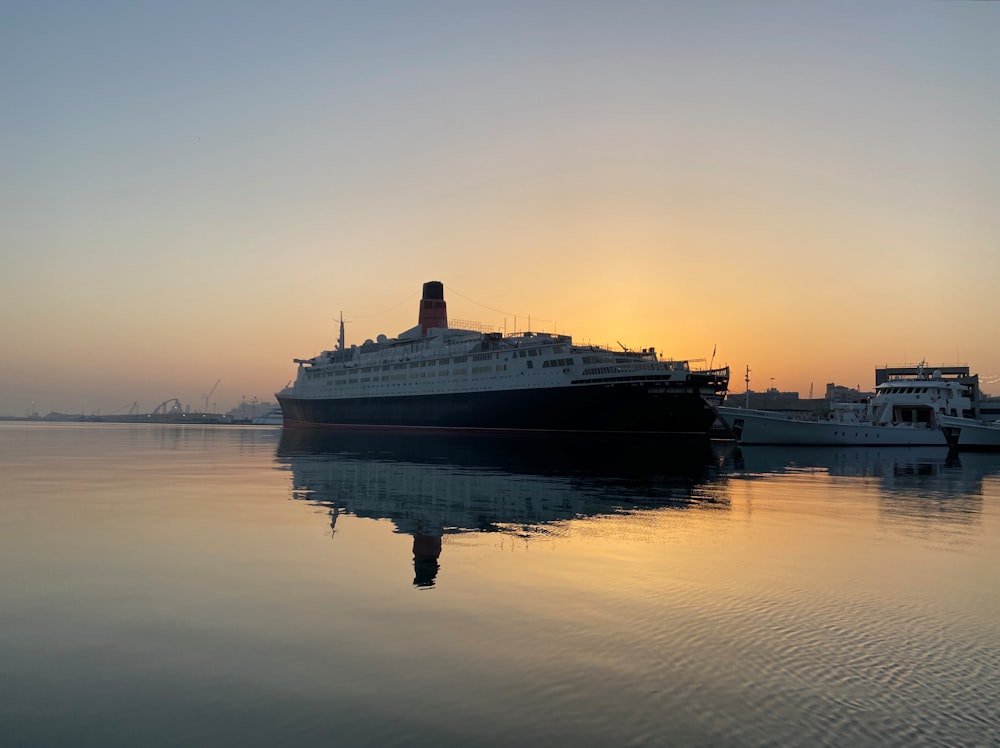 a cruise ship in the water at sunset