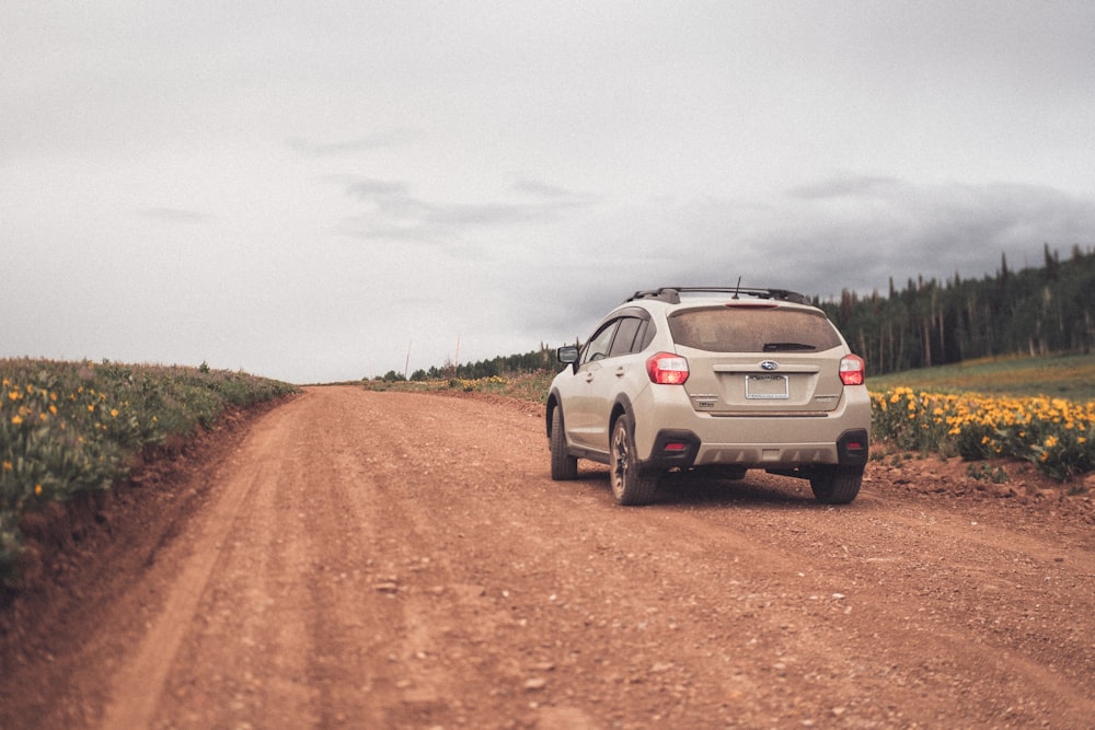 a car is driving down a dirt road