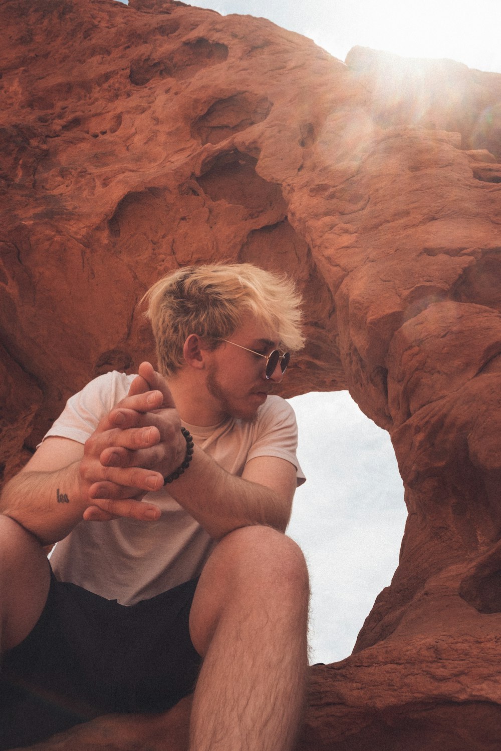 a man sitting on a rock in the desert