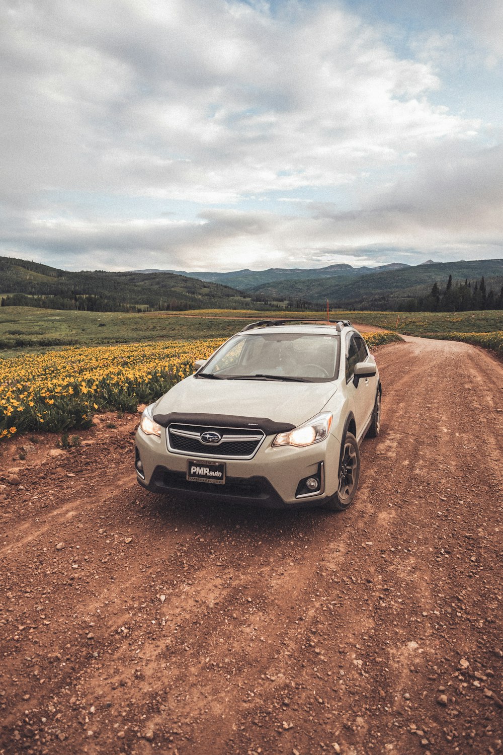 a car is parked on a dirt road