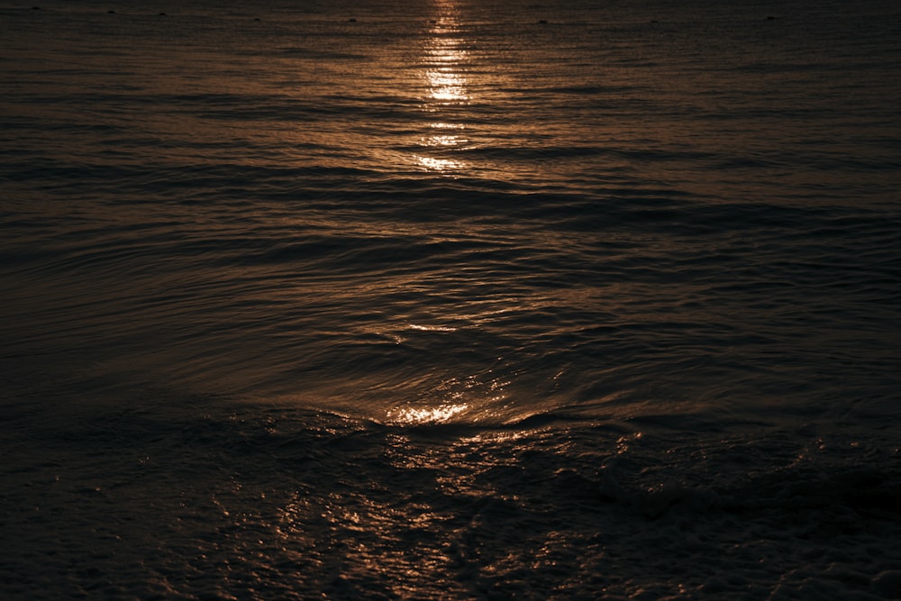 the sun is setting over the ocean with waves