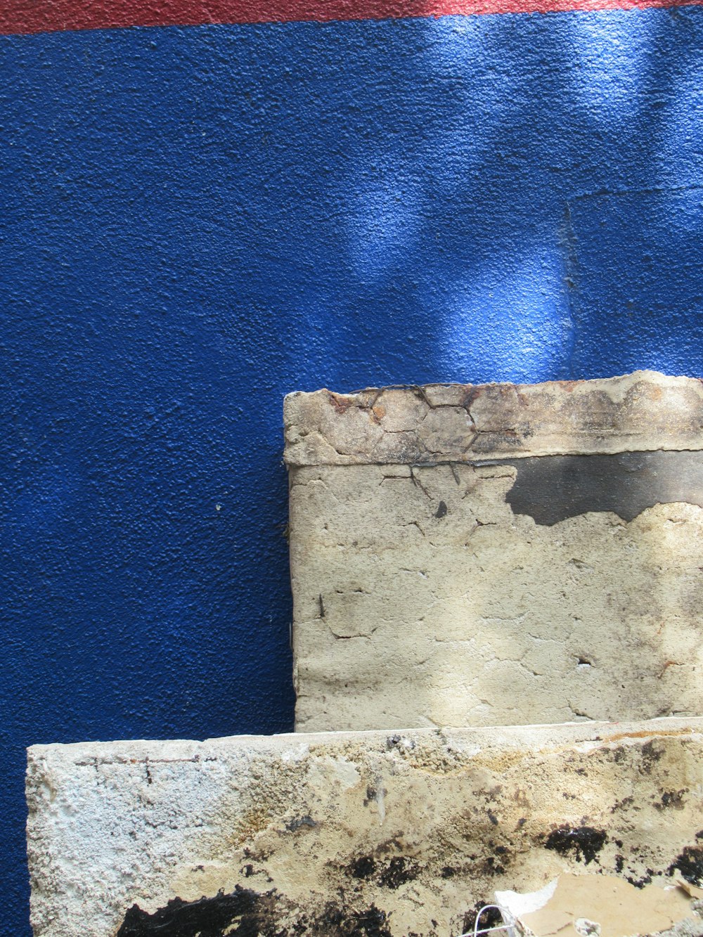 a blue and red wall with a cement block