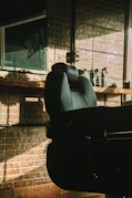 a black chair sitting in front of a brick wall