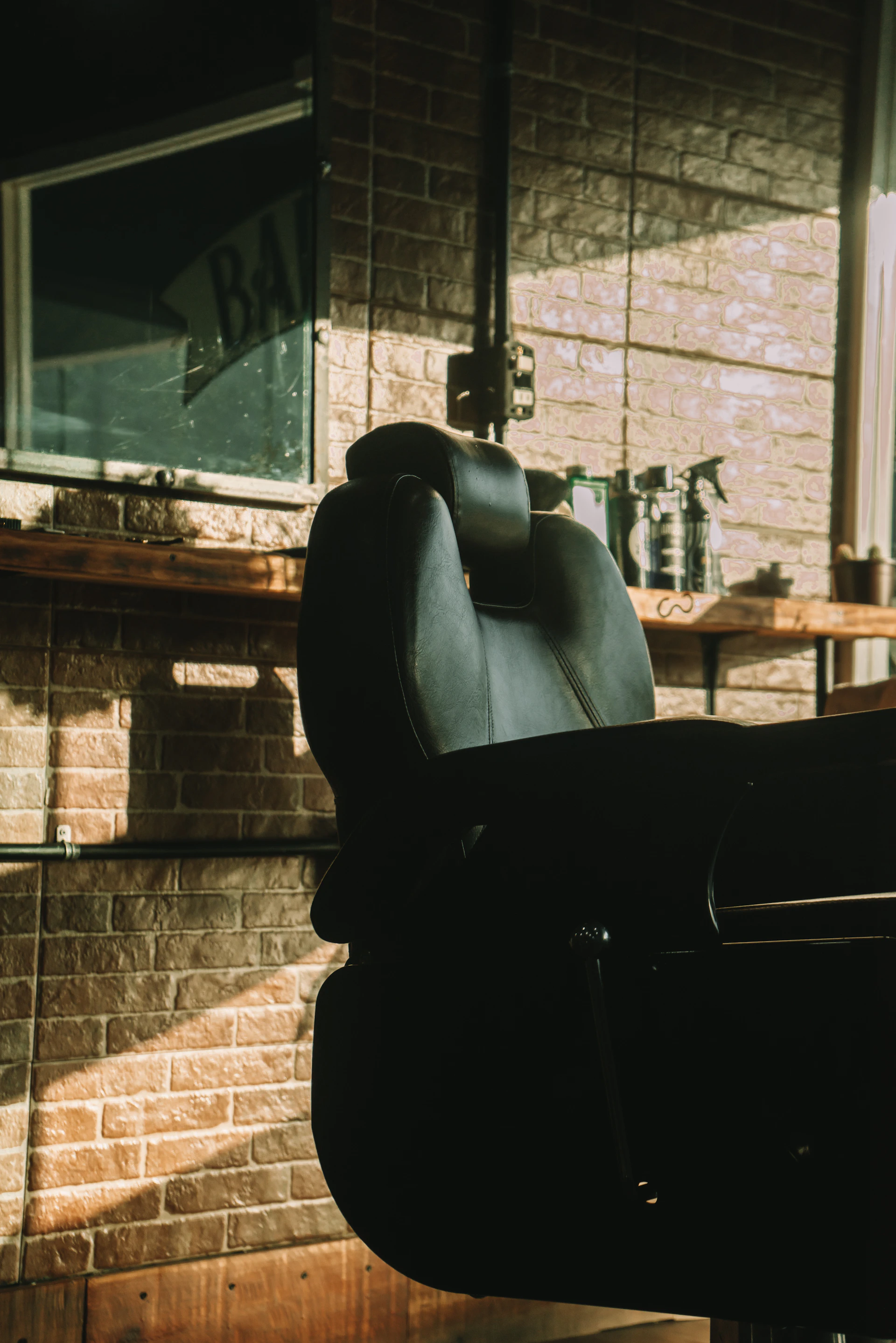 a black chair sitting in front of a brick wall