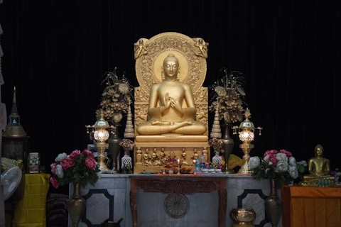 a golden buddha statue sitting on top of a table