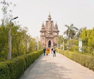 a group of people walking down a sidewalk next to a tall building