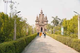 a group of people walking down a sidewalk next to a tall building