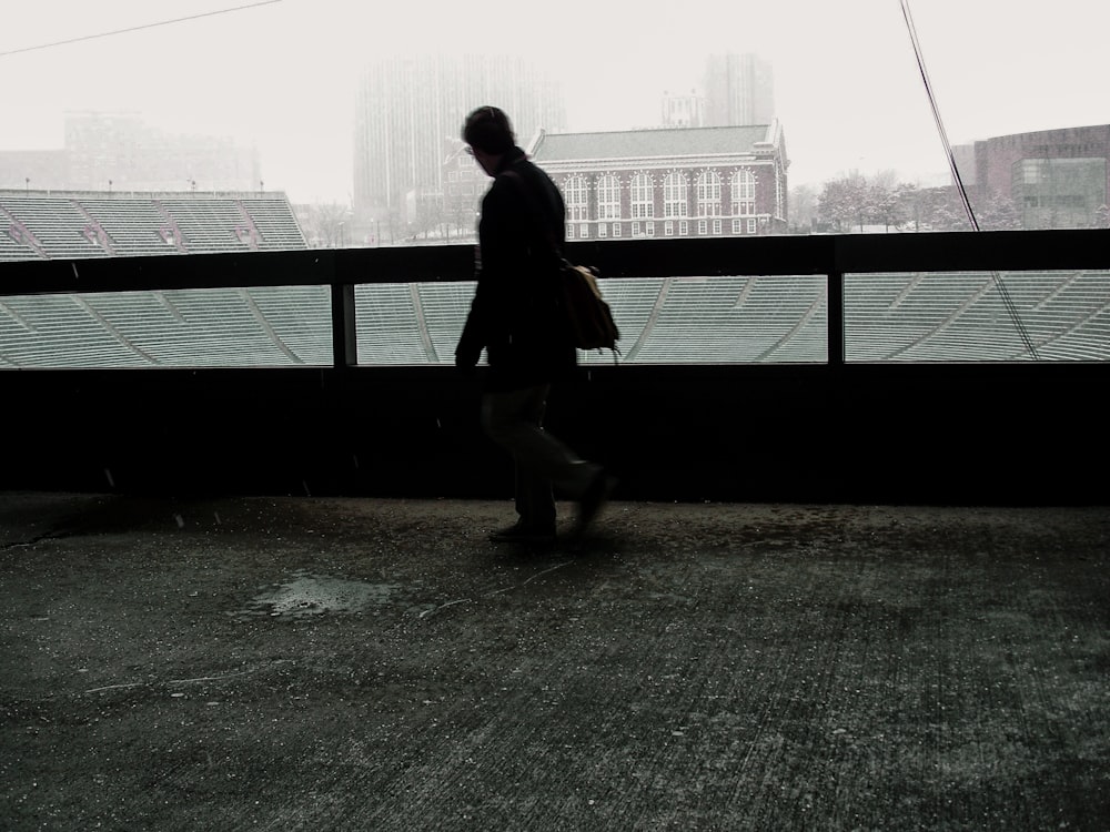 a person walking down a street next to a stadium