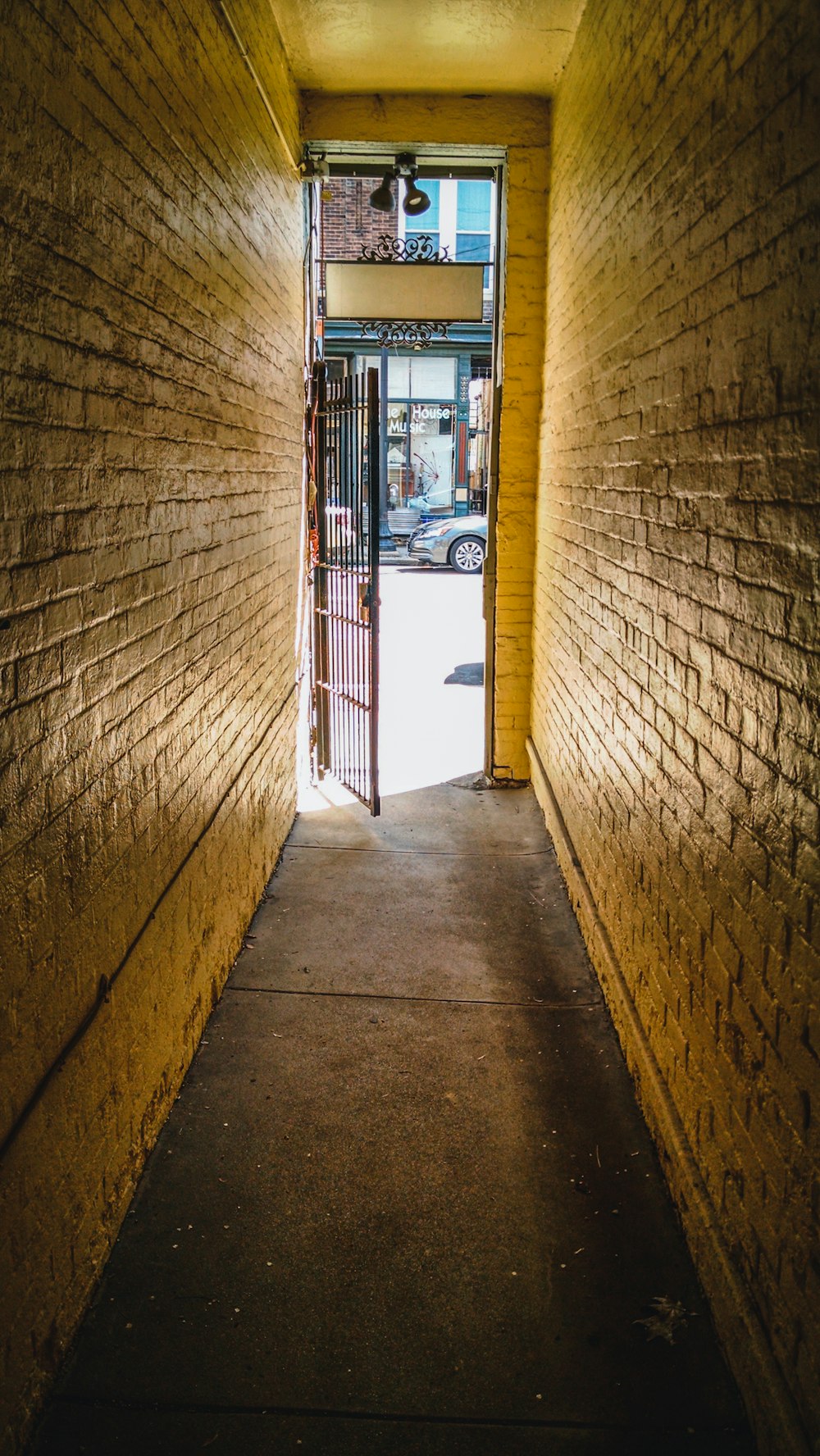a long narrow hallway with a door leading to a parking garage
