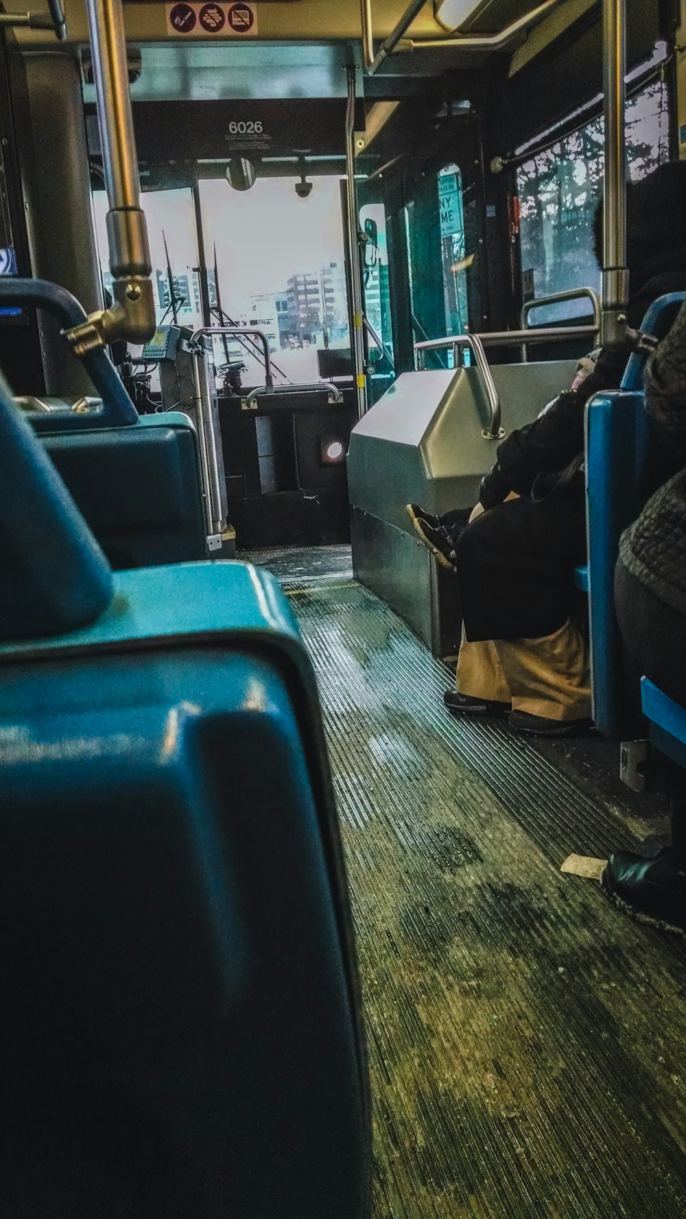 a man sitting on a bus with his legs crossed