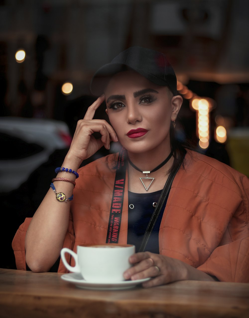 a woman sitting at a table with a cup of coffee