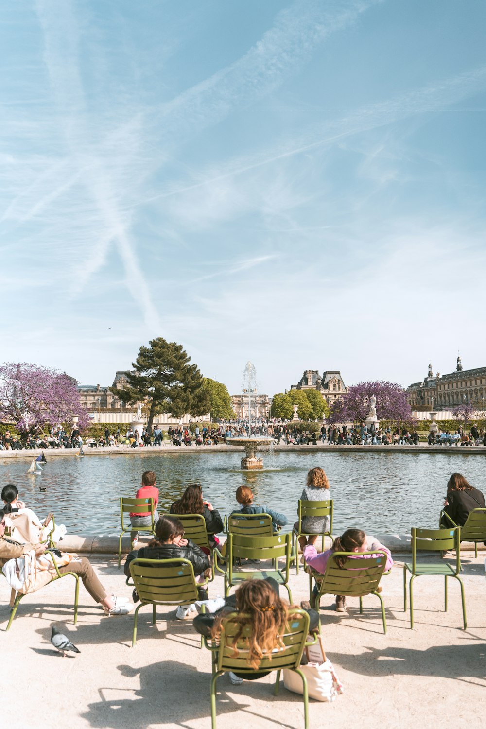 a group of people sitting on lawn chairs in front of a lake