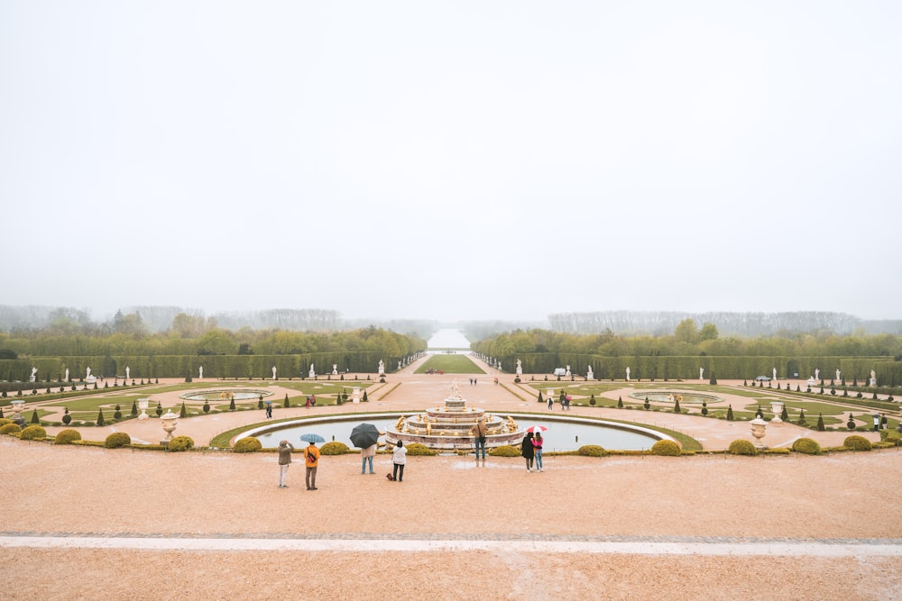 a group of people standing in front of a fountain