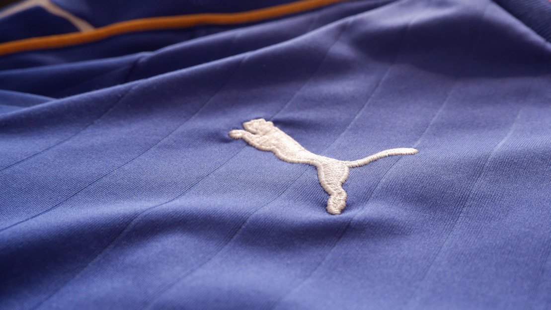 Close-up of a cozy navy blue hoodie featuring the Piercecc logo embroidered on the chest