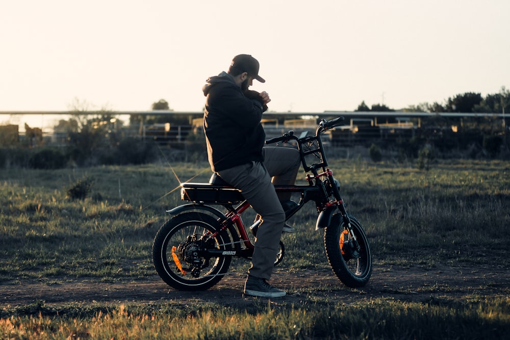 a man sitting on a bike in a field