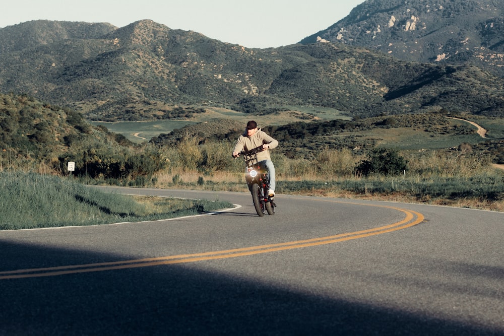 a man riding a bike down a curvy road