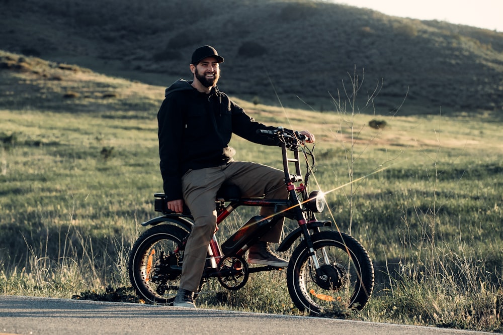 a man sitting on a bike on the side of a road