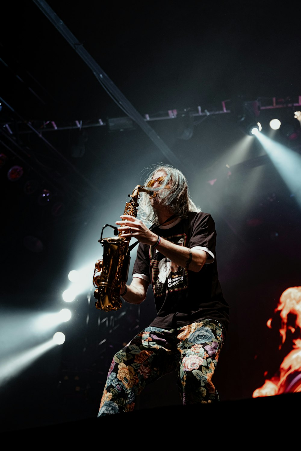 a man standing on a stage holding a saxophone