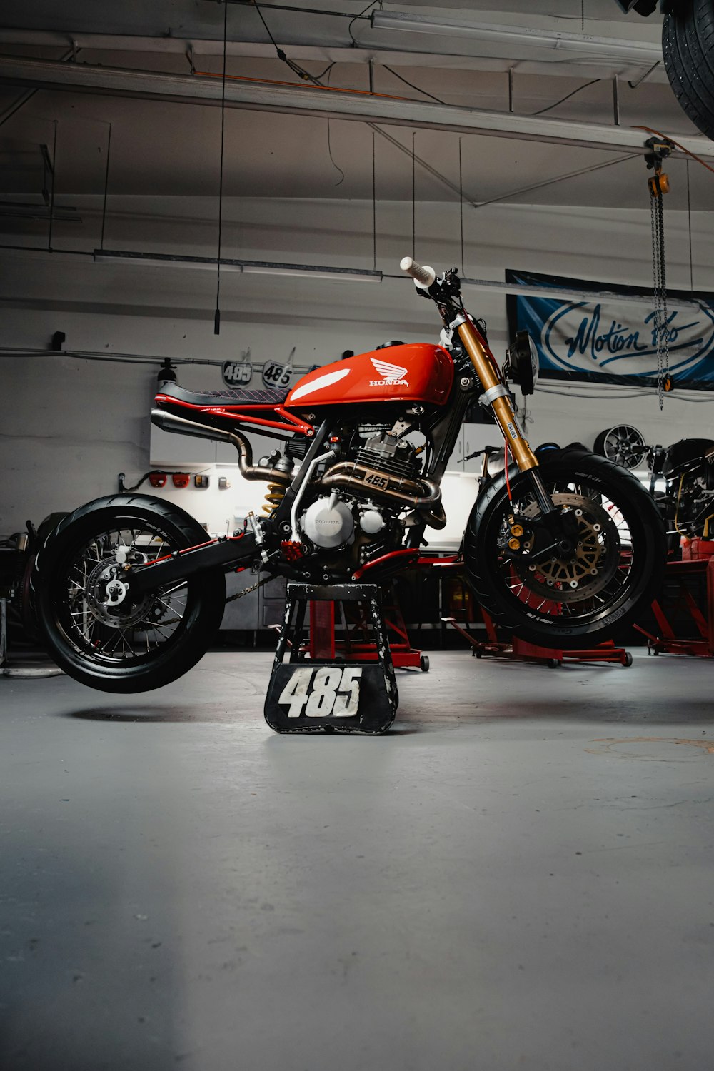 a red motorcycle is parked in a garage