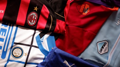 A vibrant display of custom soccer jerseys hanging with club logos and player names