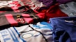 A collection of colorful soccer jerseys is laid out, each featuring distinctive team logos and color patterns. The jerseys include stripes, stars, and various shades, providing a rich visual contrast.