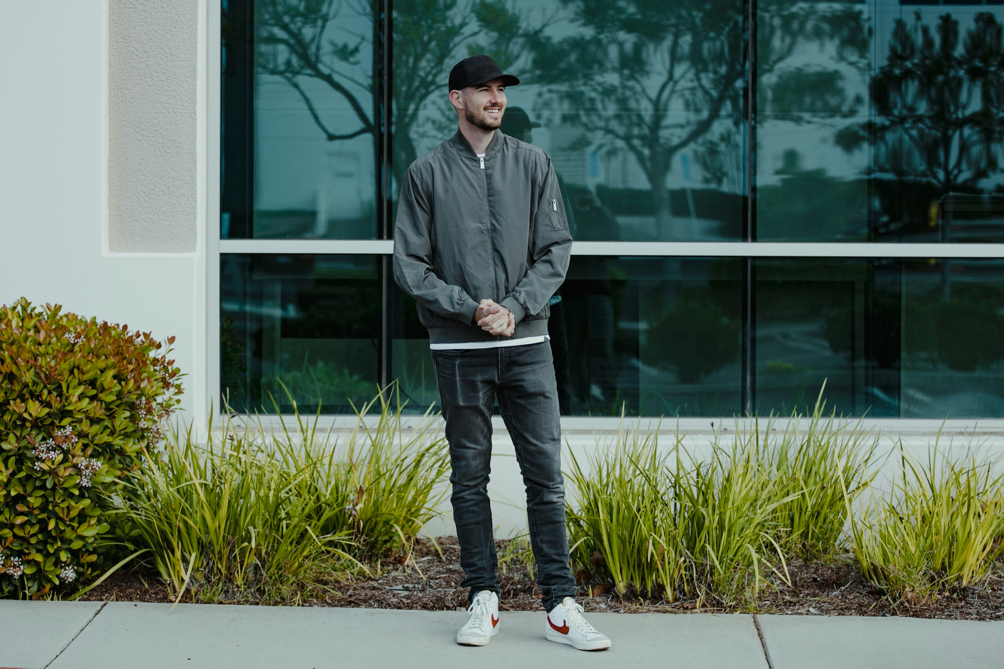 a man standing on a sidewalk in front of a building