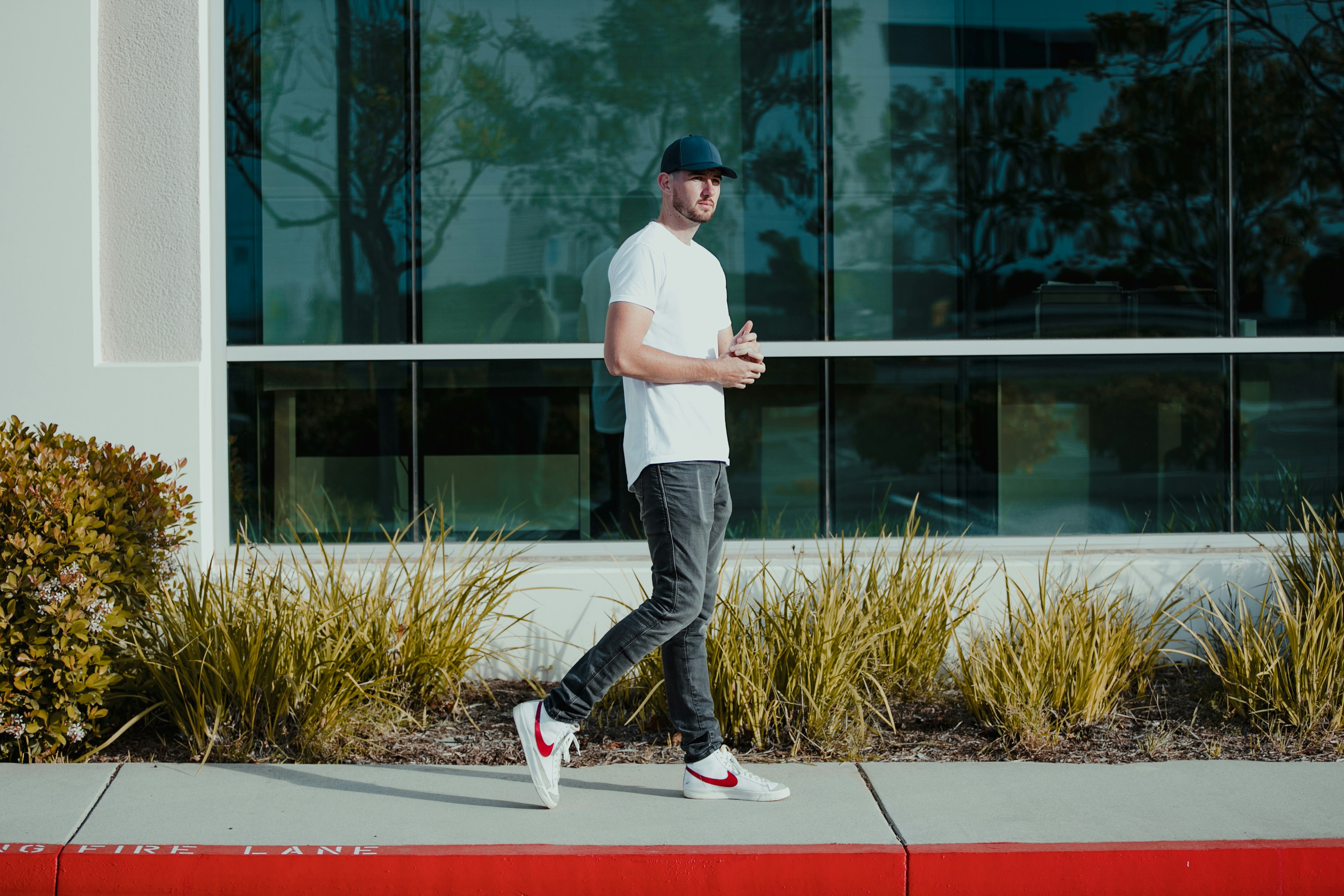 A man walking down a sidewalk in front of a building photo – Free Man ...