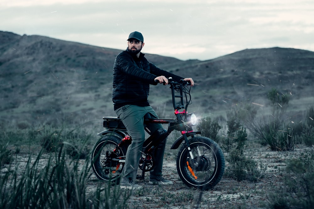 a man sitting on top of a bike in the desert